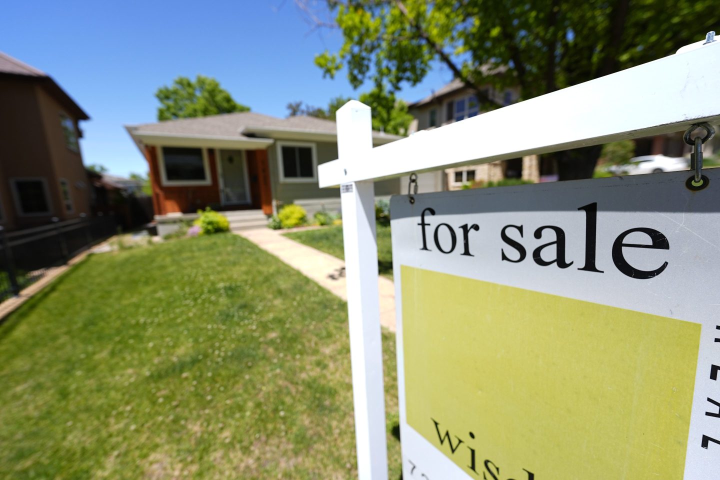 A for sale sign stands outside a single-family residence on May 22, 2024, in southeast Denver.