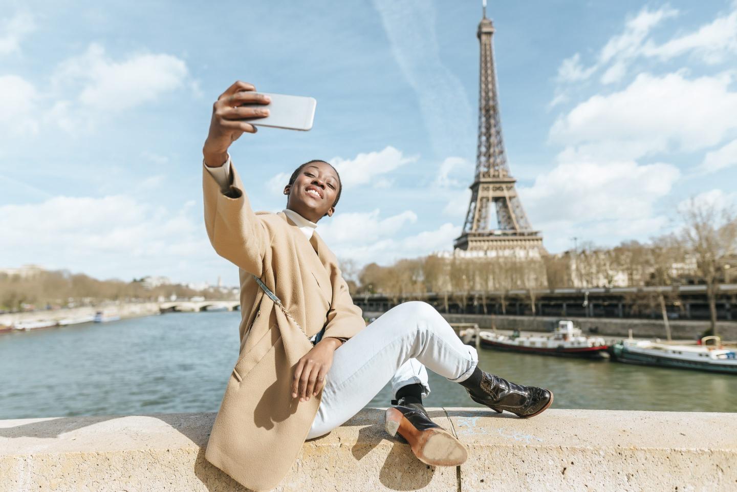 woman takes selfie near Eiffel tower