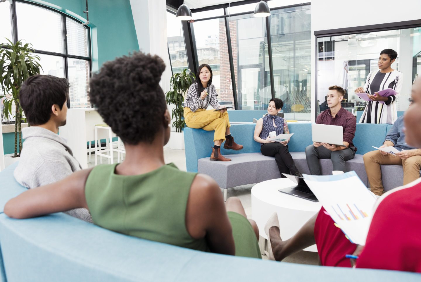Businesswoman leading informal meeting in modern open plan office