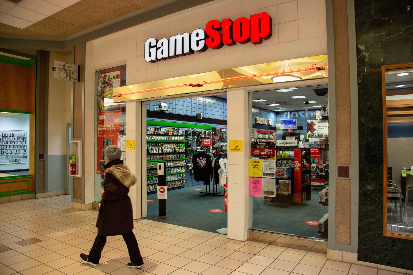 person walks past GameStop store