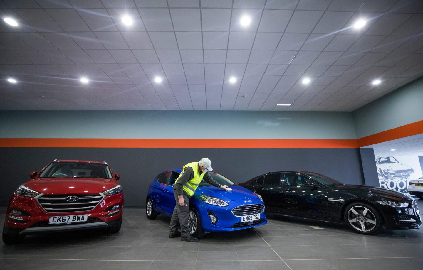 cars lined up in a cazoo showroom