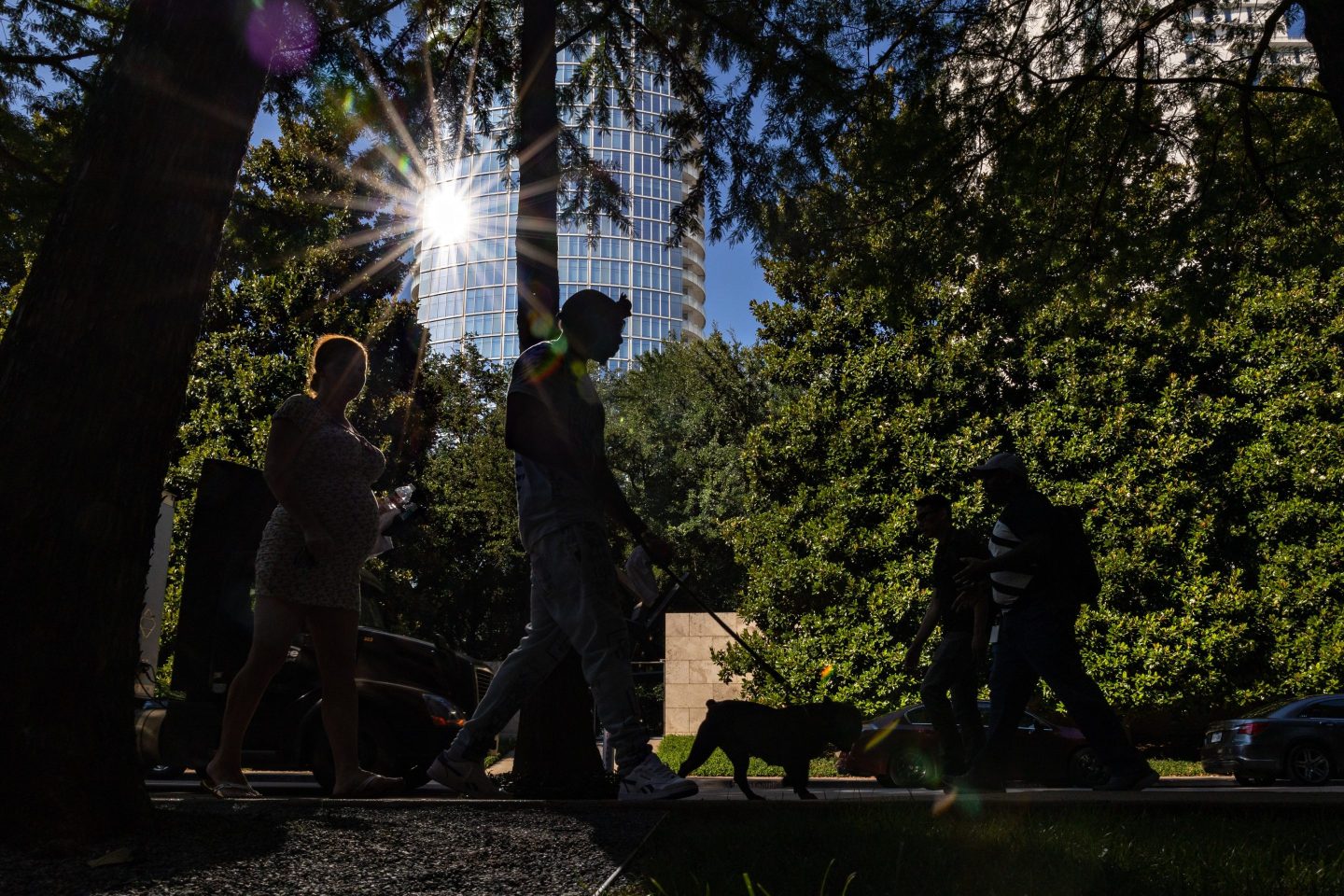 Pedestrians walk along a street during a heatwave in Dallas, Texas, US, on Tuesday, June 21, 2022. A heat wave has returned to parts of the South and Midwest this week and will threaten dozens of daily record highs for the official first days of summer, the Weather Channel reports. Photographer: Shelby Tauber/Bloomberg via Getty Images