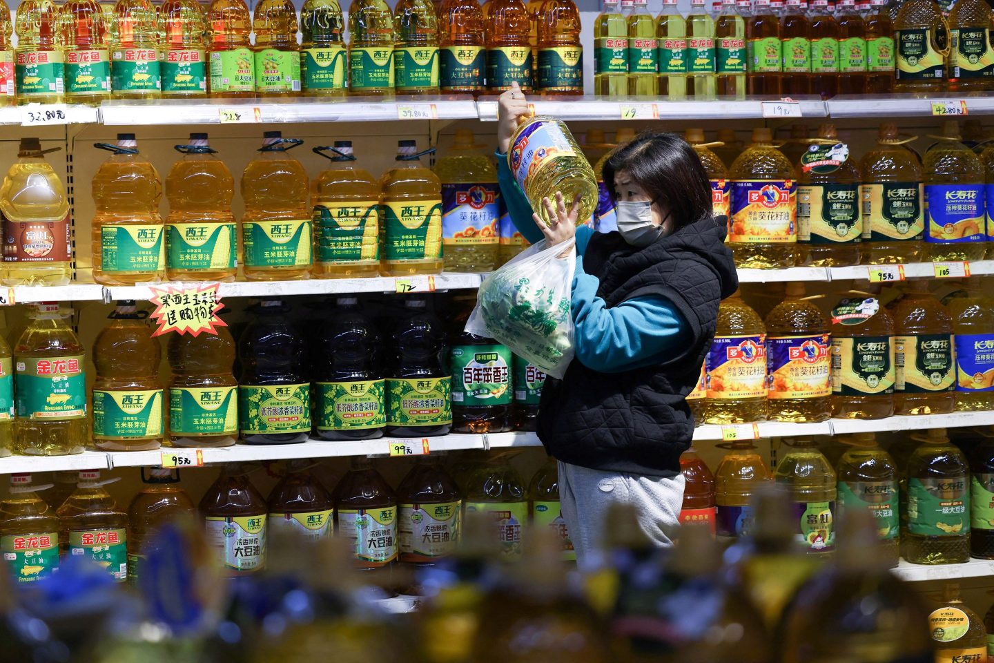 A customer shops for cooking oil at a market in Shenyang, China.