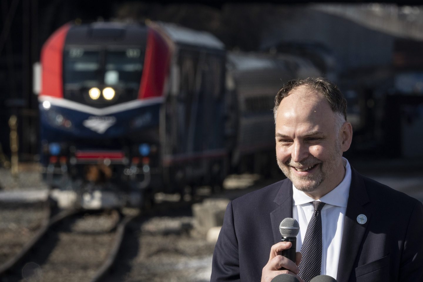 Amtrak CEO Stephen Gardner with an approaching train in the background