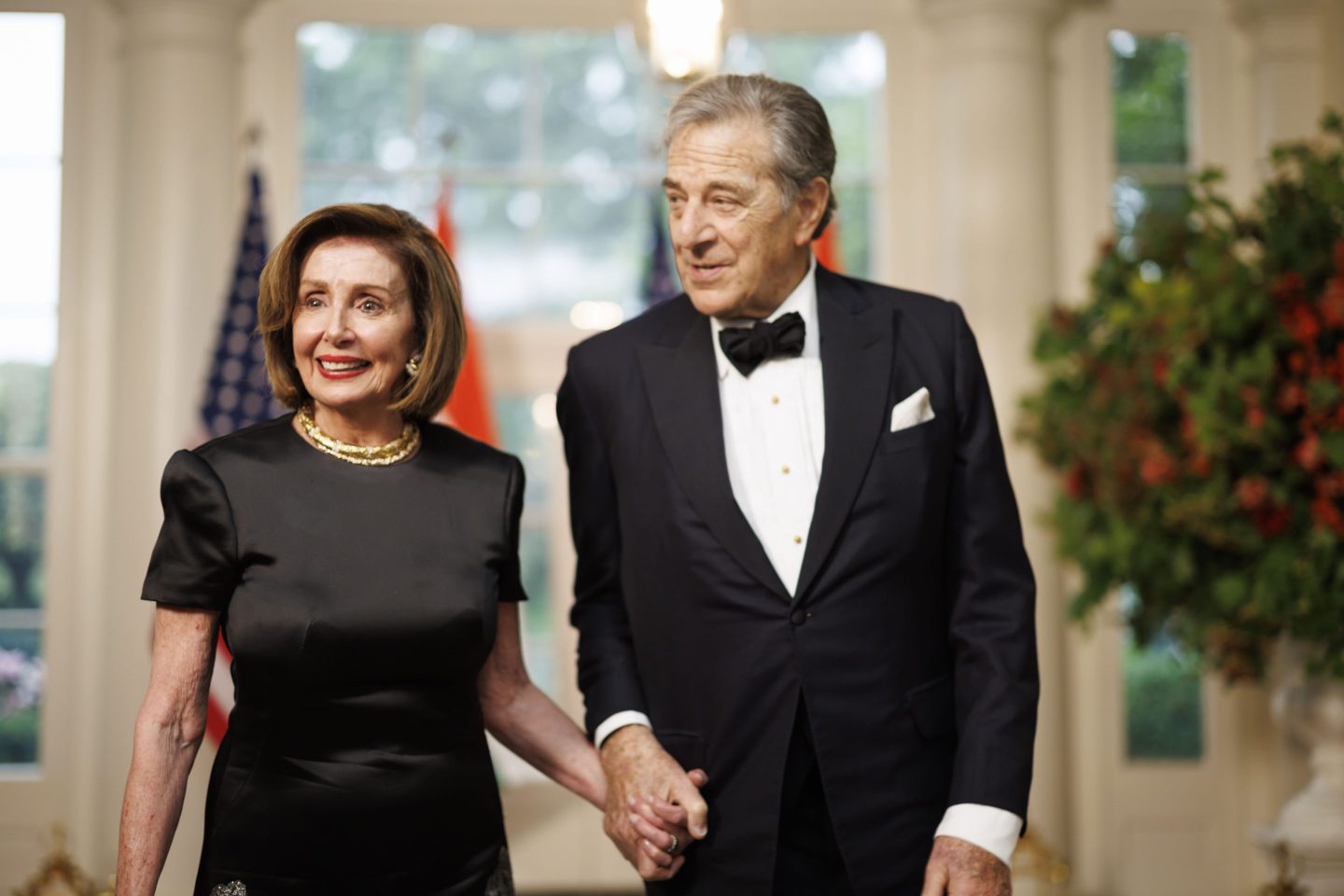 Nancy and Paul Pelosi hold hands