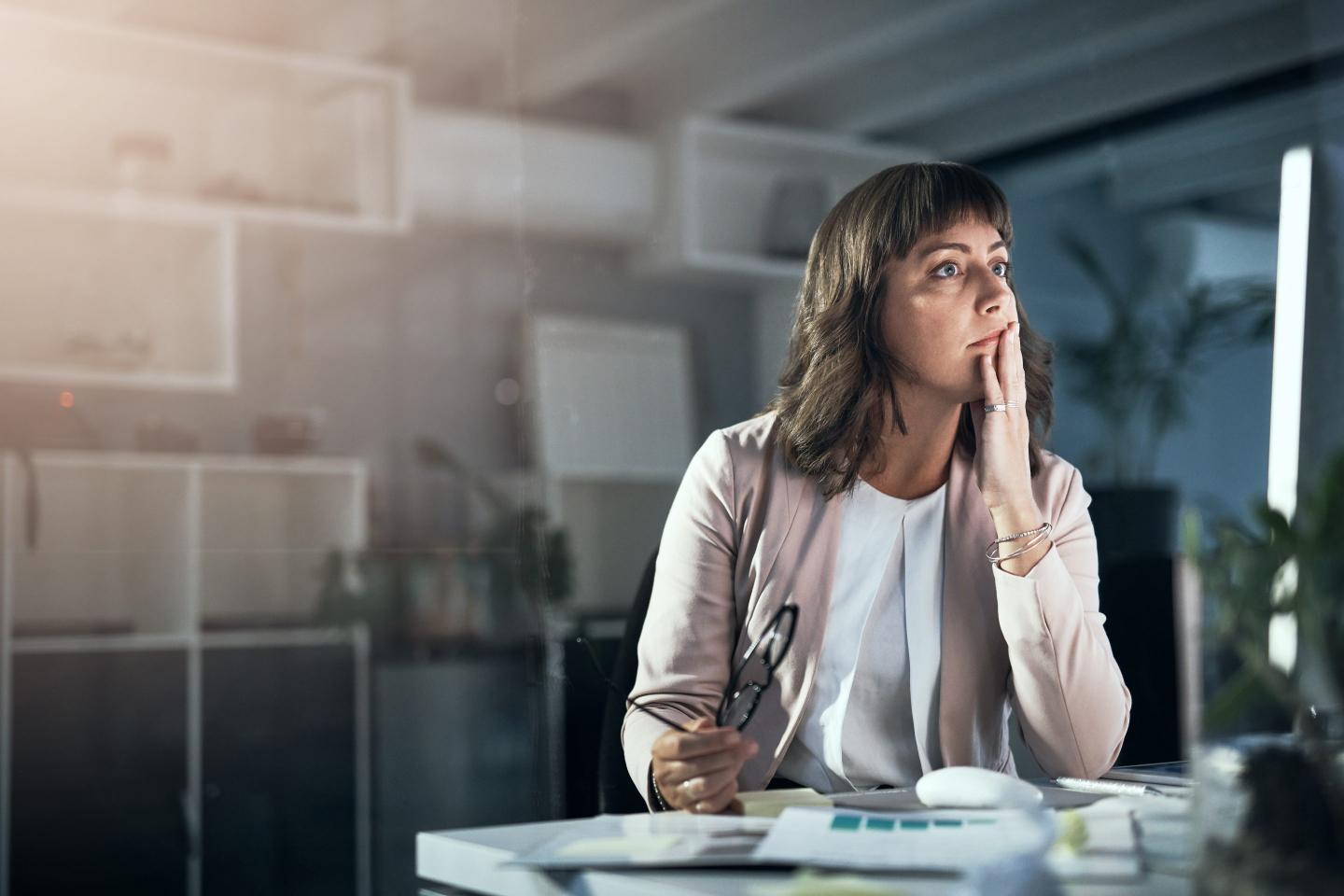 HR manager is deep in thought at her desk.