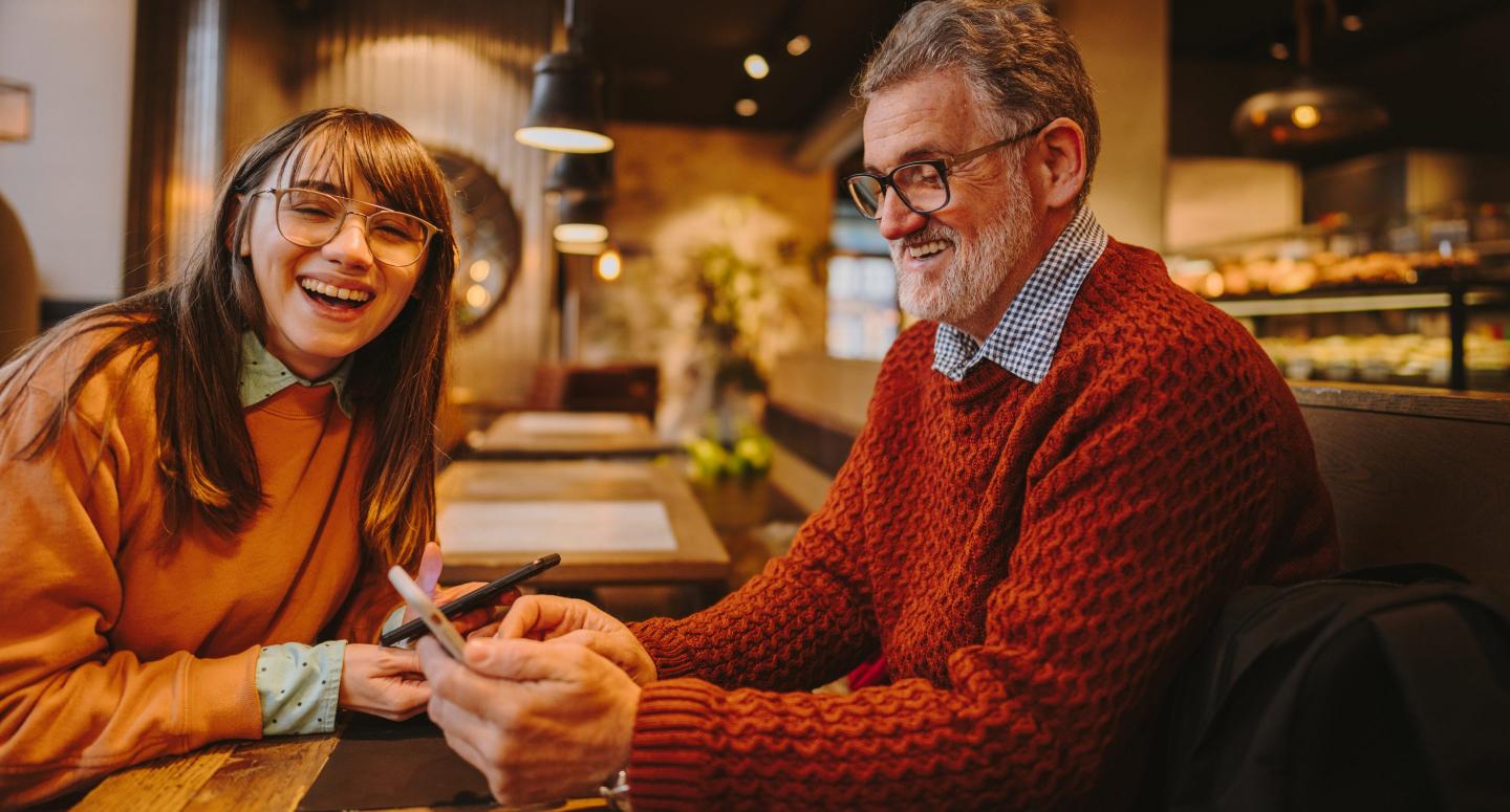 A young woman and a middle aged man laughing