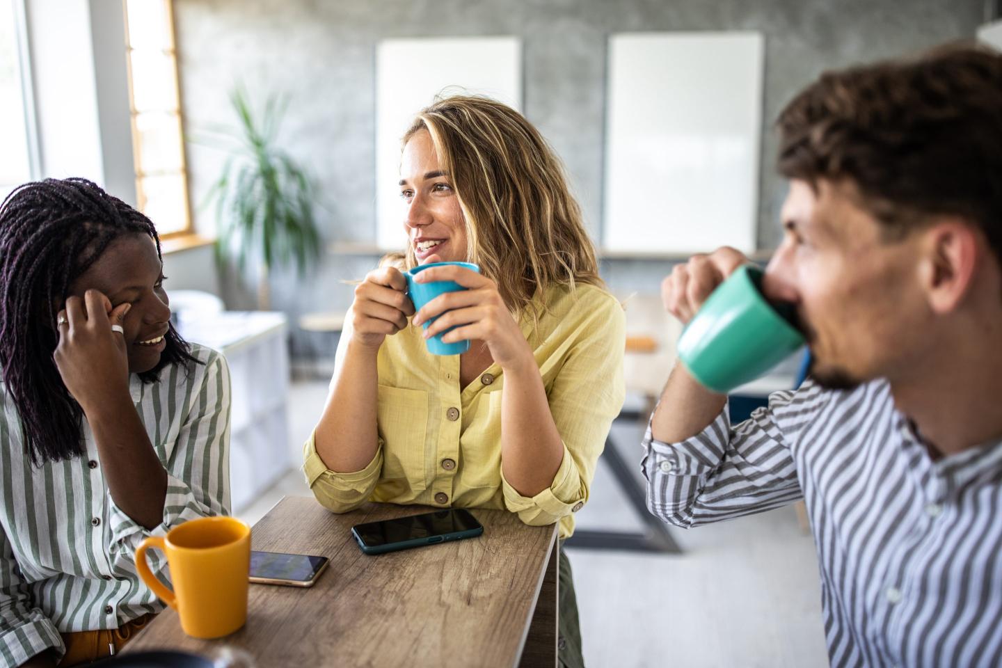 Young coworkers talk in office.