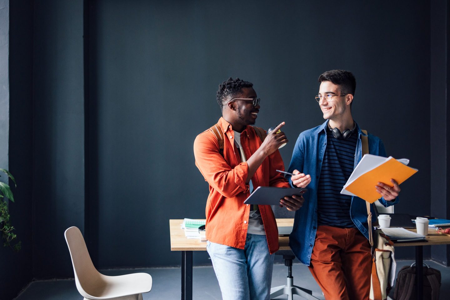 Two coworkers chat at an office.