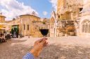 Man drinking red wine in Saint-Emilion village, personal perspective view, Bordeaux, France