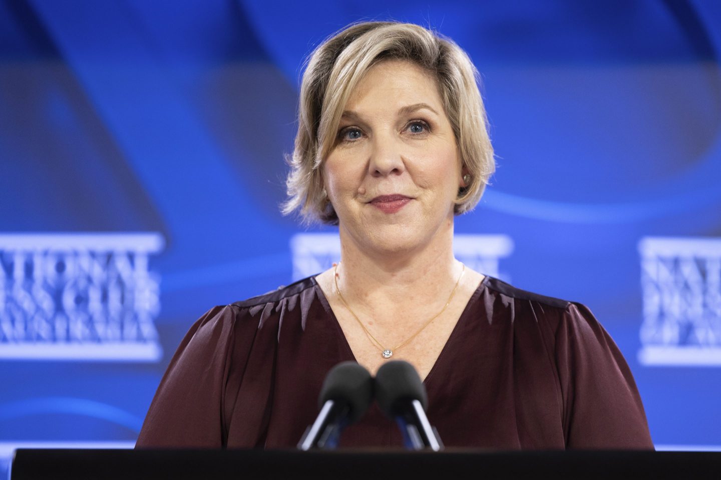 Robyn Denholm with microphones before her