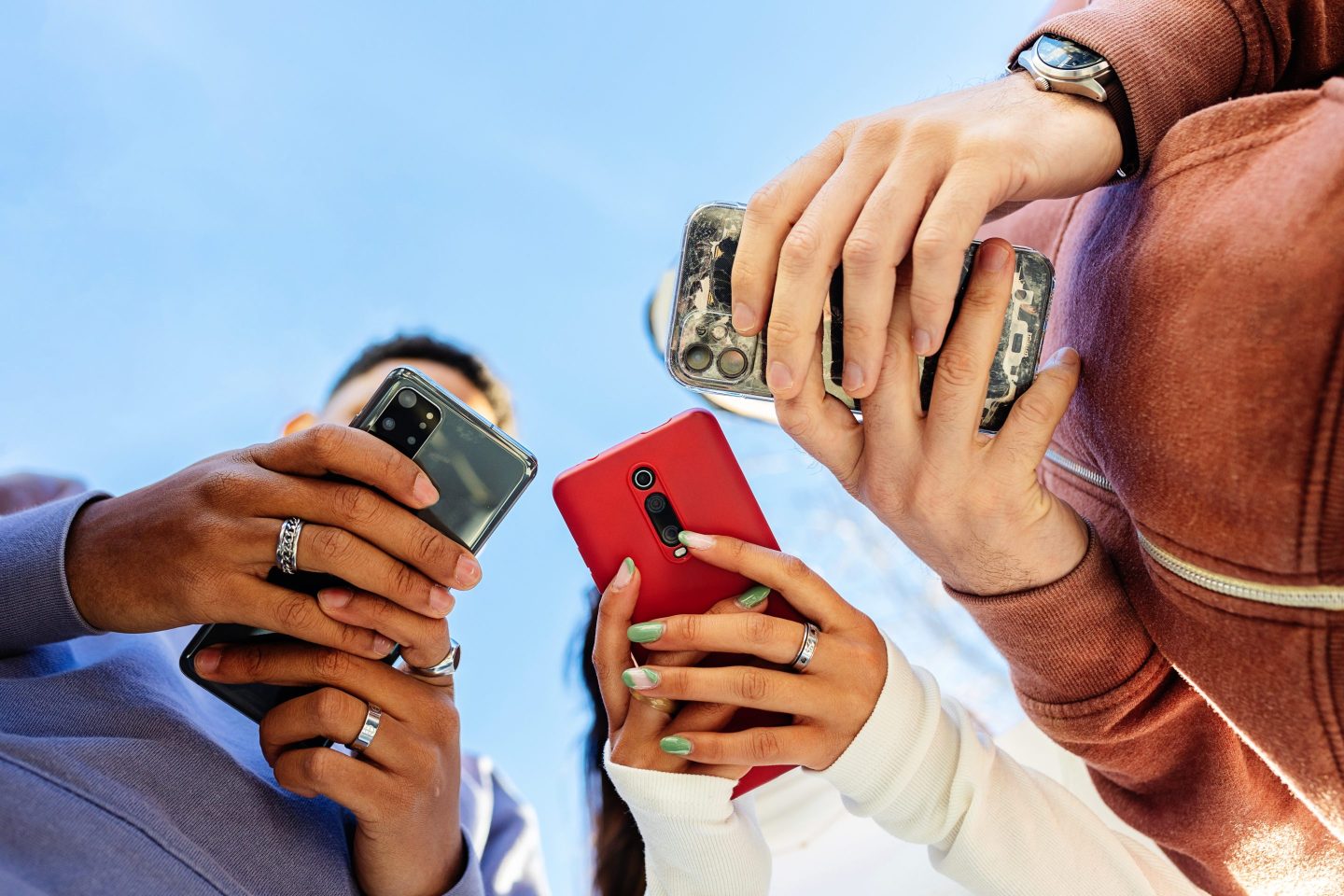 3 people holding their phones