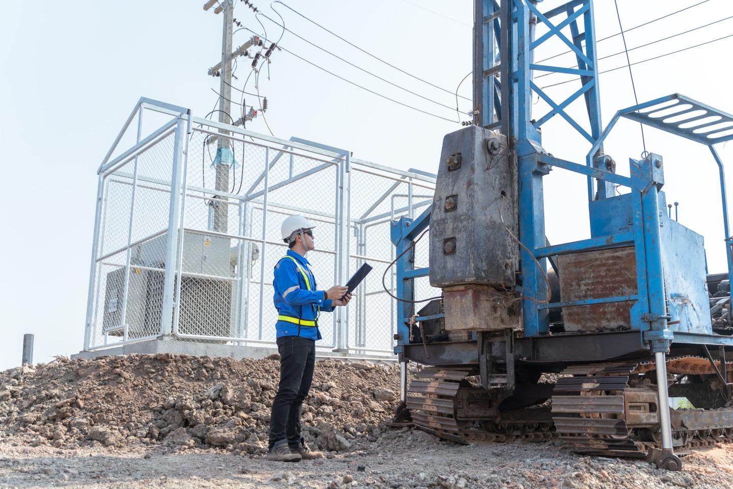 person standing next to a drill machine