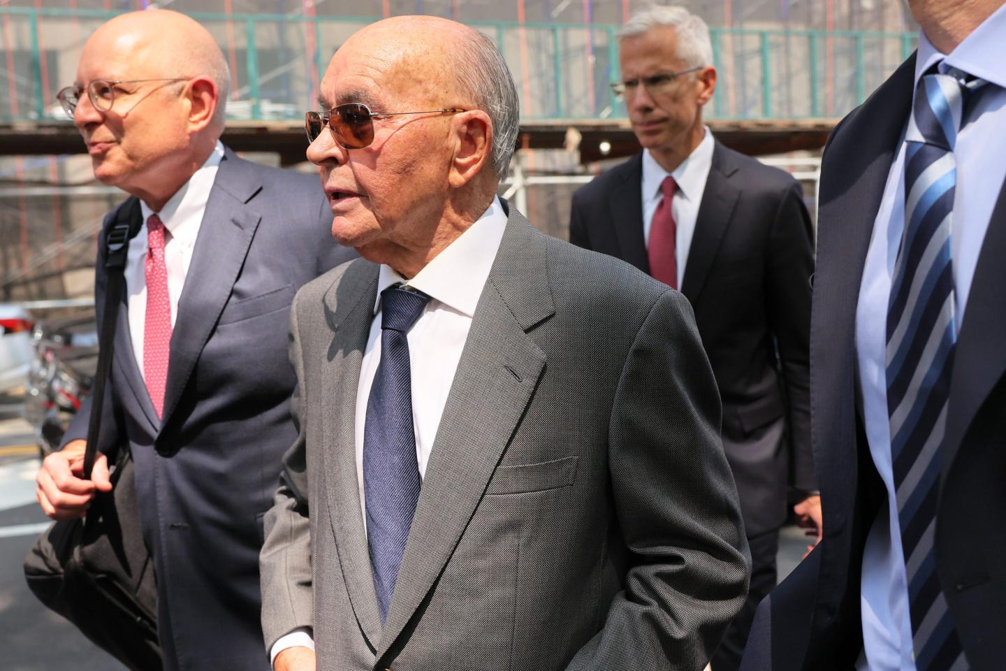 British billionaire Joe Lewis is escorted by his attorneys after leaving Manhattan Federal Court on July 26, 2023 in New York City