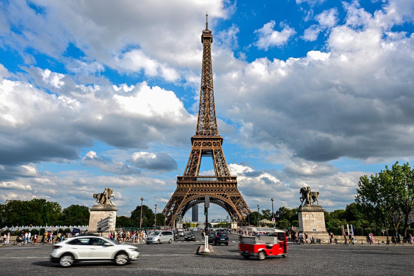 vehicles driving in front of the eiffel tower