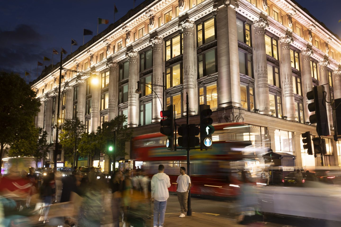 Selfridges department store is lit up at dusk on Oxford Street