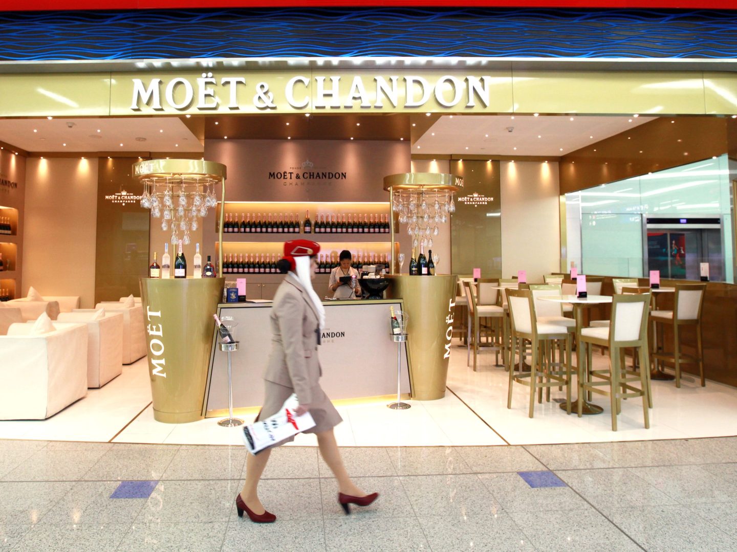 An Emirates Airline employee walks past the Moet and Chandon champagne bar inside terminal 3 at concourse A, the new A380 terminal at Dubai International Airport in Dubai, United Arab Emirates, on Monday, Feb. 25, 2013. Dedicated for use by Emirates Airline the terminal 3 complex includes an associated airside facility known as Concourse B and a purpose-built facility for Airbus A380 known as Concourse A. Photographer: Gabriela Maj/Bloomberg via Getty Images