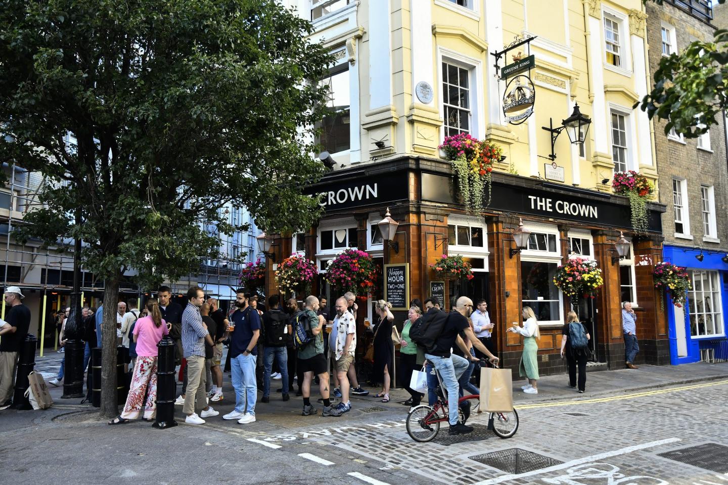 General view of people drinking beer outside a pub in the Seven Dials district in London, England.