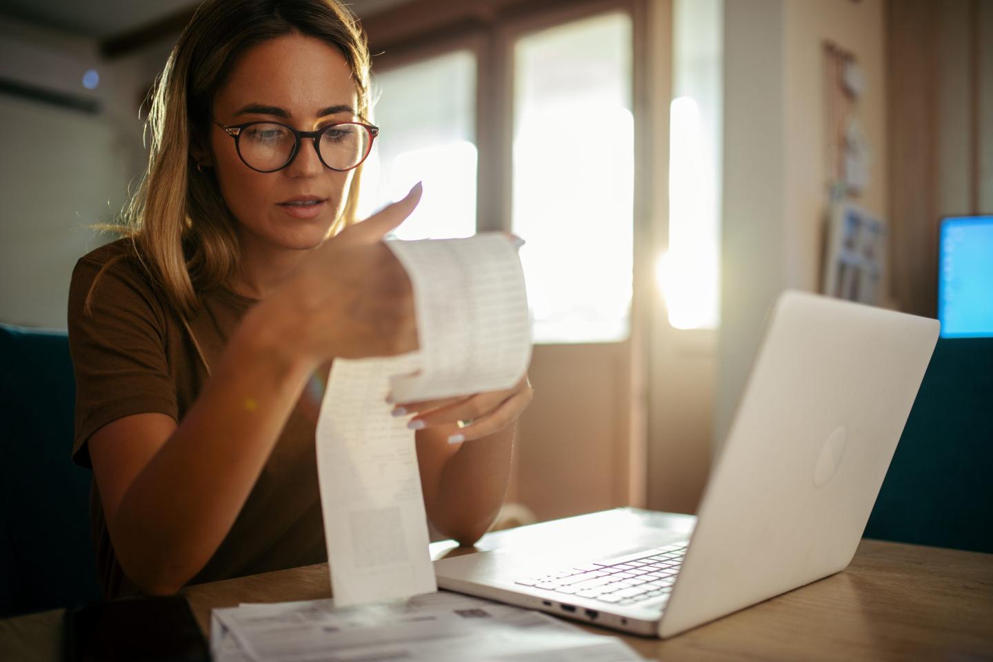 Young women looks at a paper statement with concern