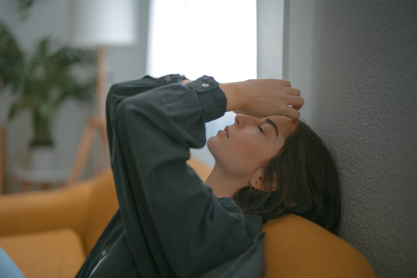 young woman leans back with eyes closed