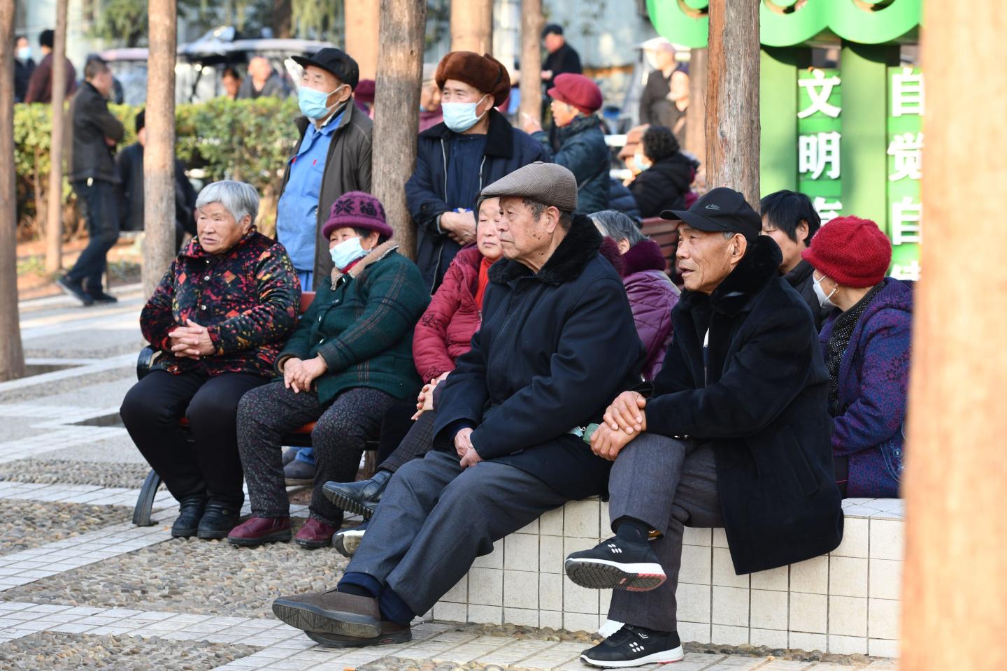 Elderly Chinese people sit together at a park