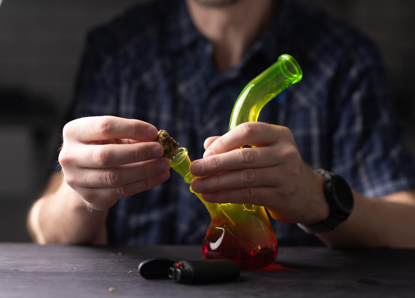 Man Fills Bong With Cannabis Leaves