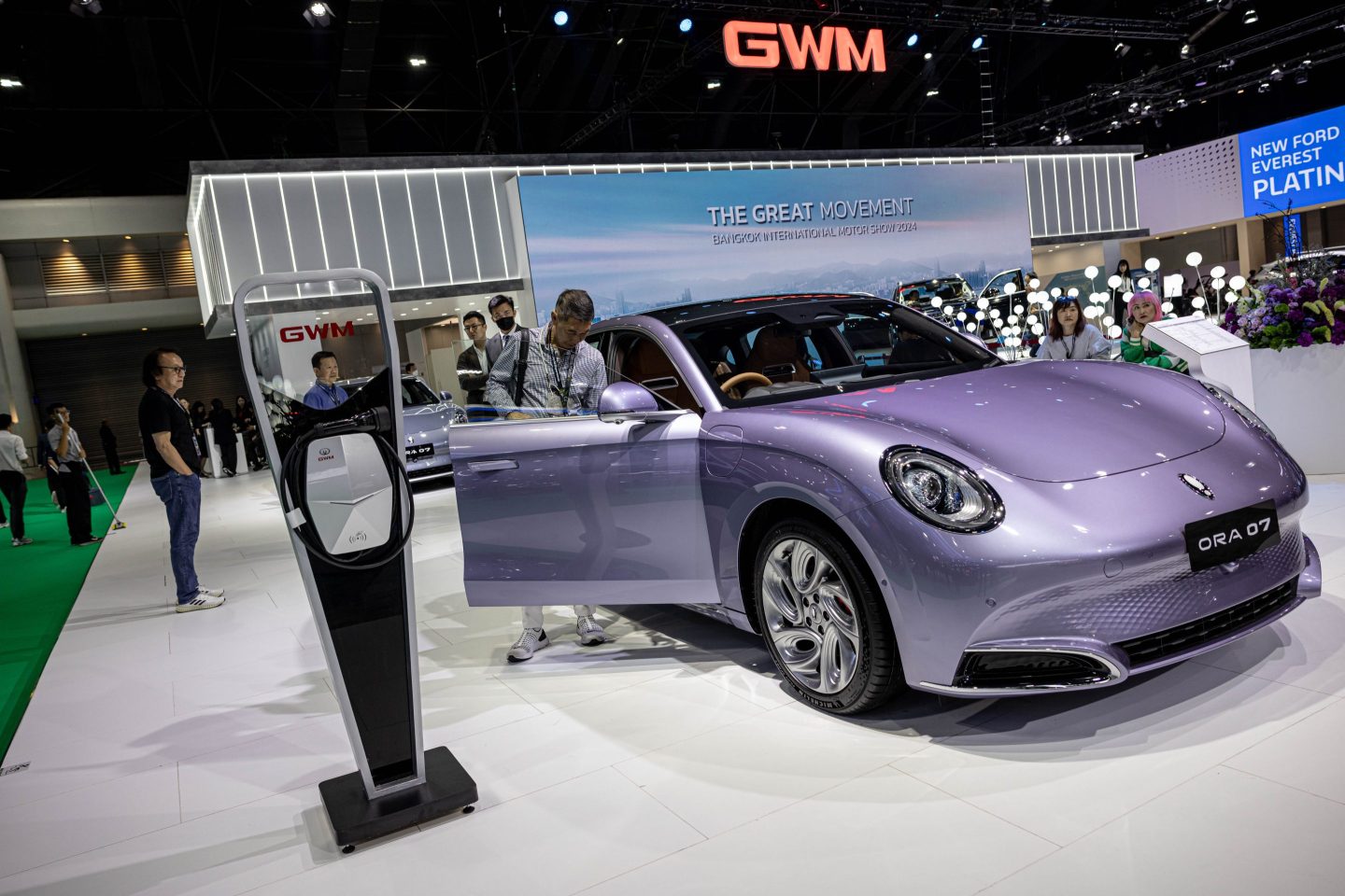 A Great Wall Motor Co. charging station next to the company's Ora 07 electric vehicle on display at the Bangkok International Motor Show
