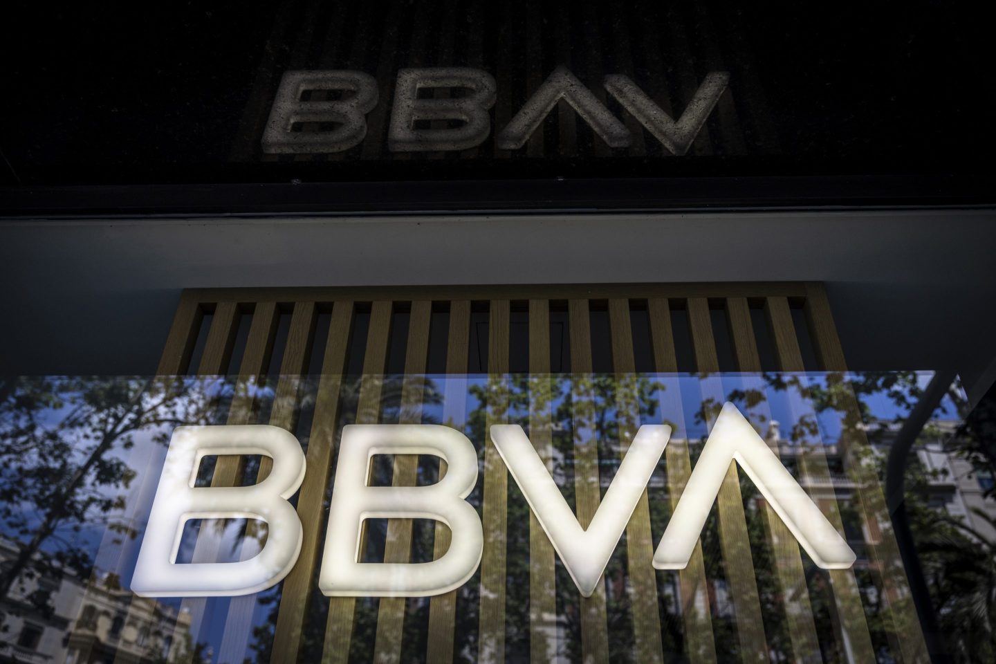 Illuminated signage at a Banco Bilbao Vizcaya Argentaria SA (BBVA), right, and a Banco Sabadell SA, left, bank branch in Barcelona, Spain, on Wednesday.