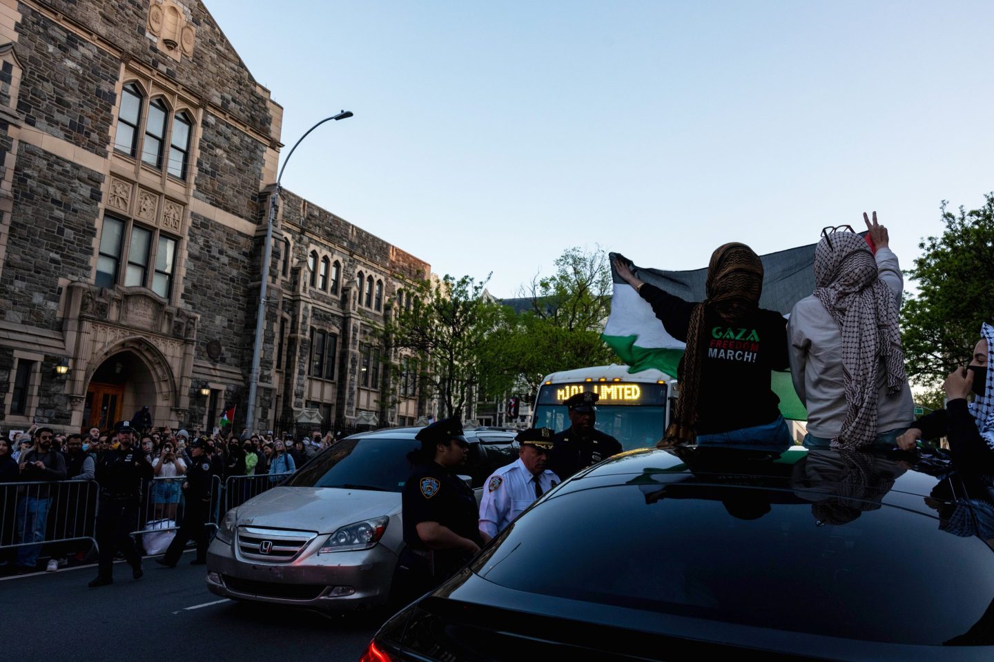 NYPD officers talk to the driver of a car who sped past a pro-Palestinian demonstration outside The City College Of New York.