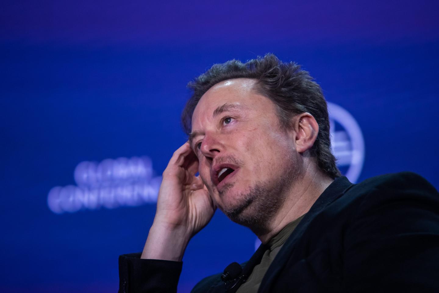 Elon Musk scratches his head