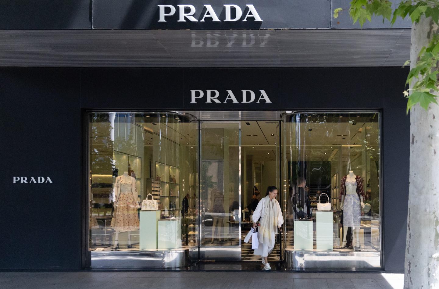 A woman leaves a Prada store on Madrid's Golden Mile on May 3, 2024, in Madrid, Spain.