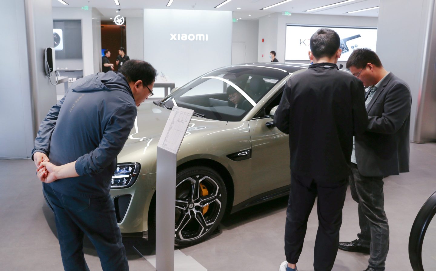 Customers examining Xiaomi's Mi Car SU7 at the flagship Mi Home Auto store in Shanghai, China, on May 10, 2024.