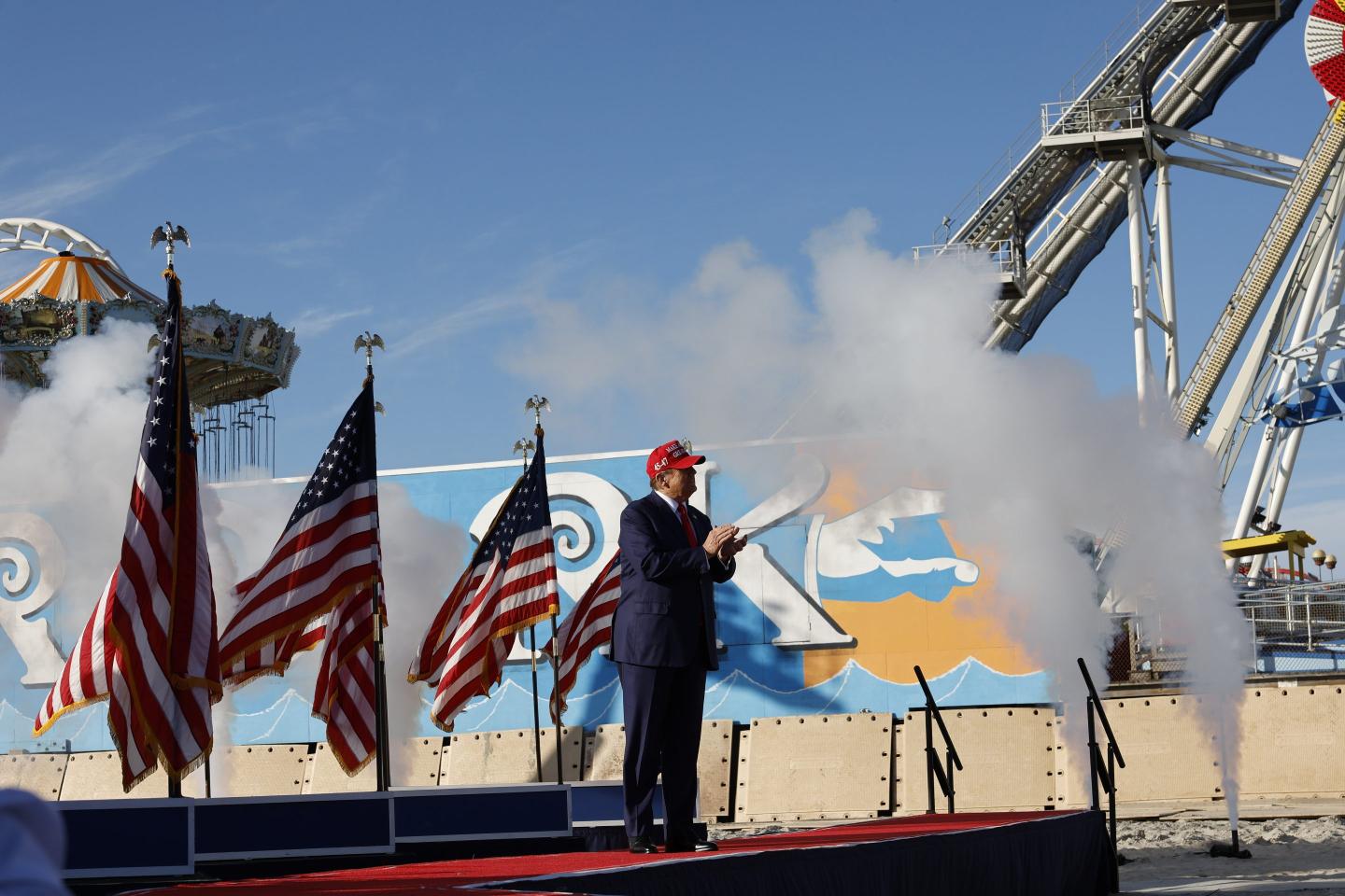 Donald Trump claps while on stage