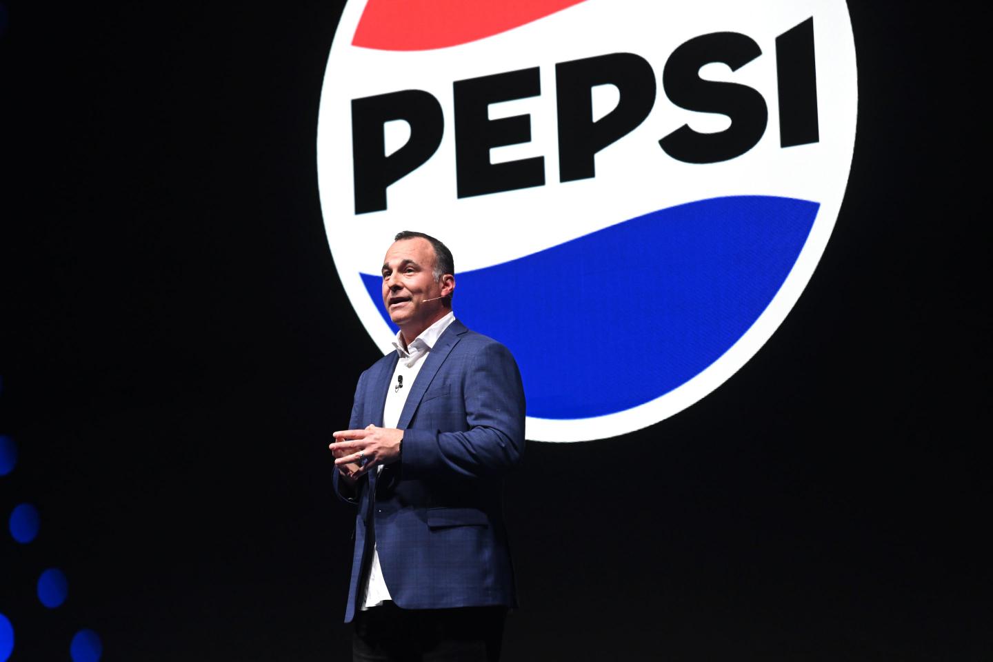 Pepsi Chief Marketing Officer Todd Kaplan stands on stage with a big Pepsi logo in the background.