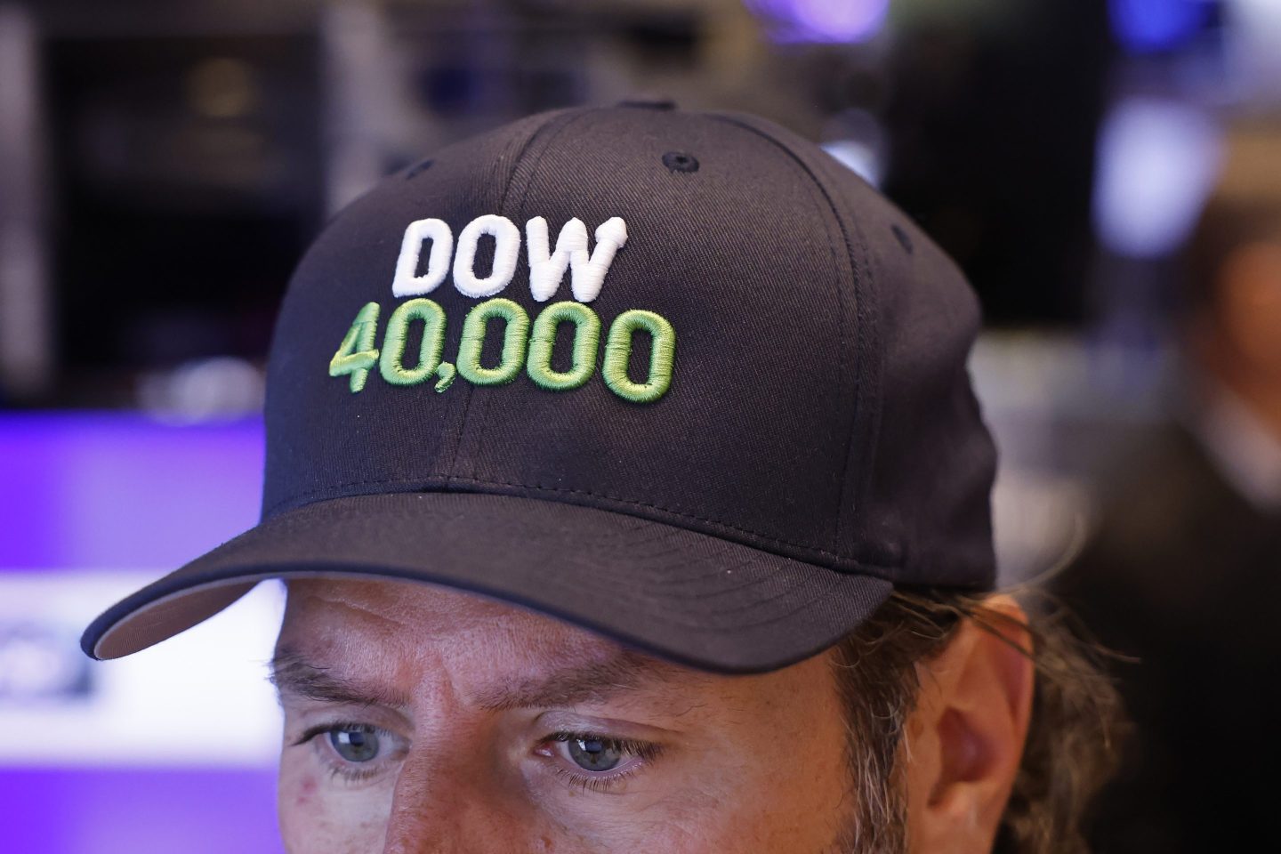 stock trader wears Dow 40,000 cap