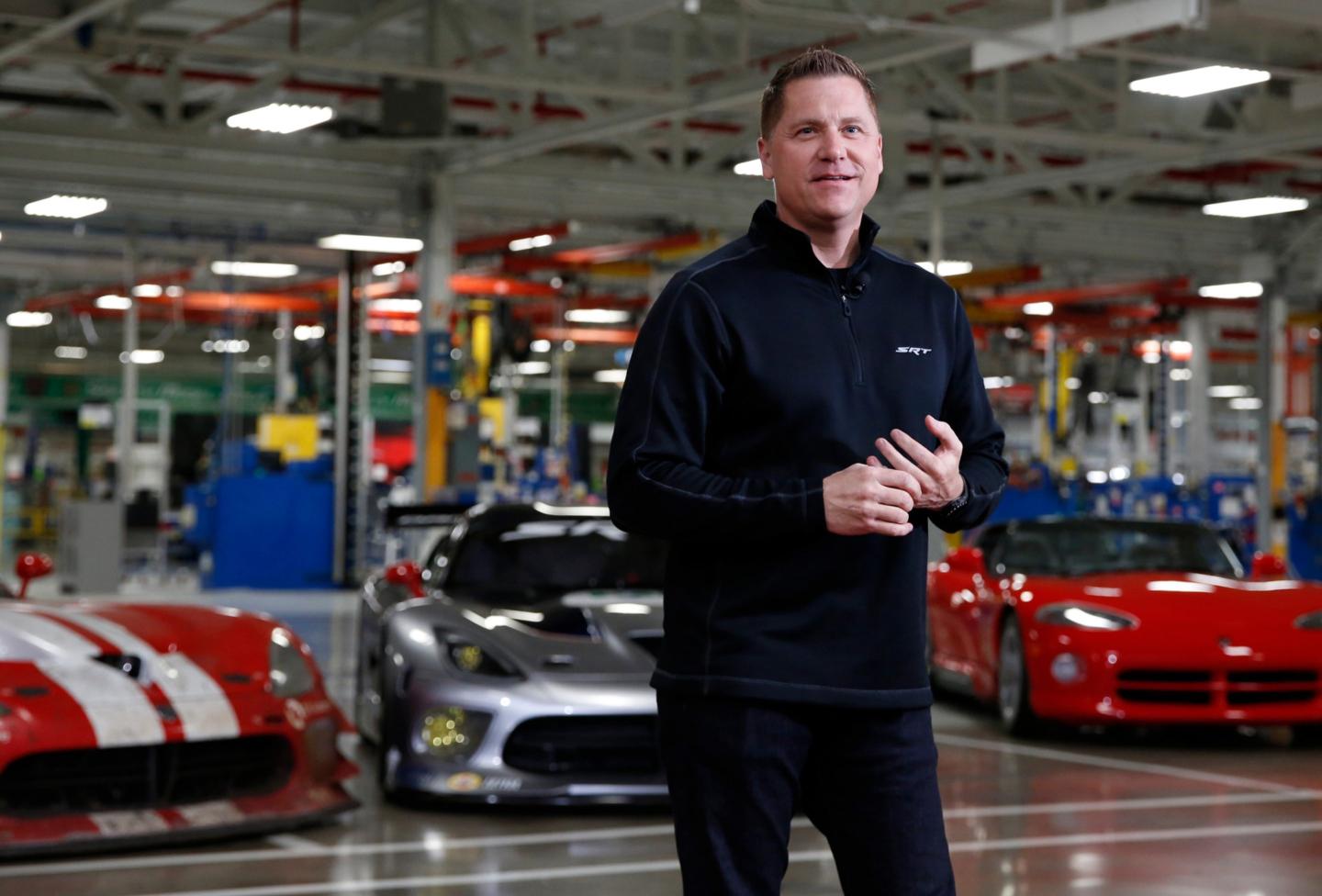 Tim Kuniskis in front of muscle cars