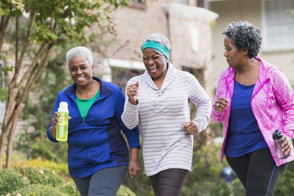 Three Black women exercising together.