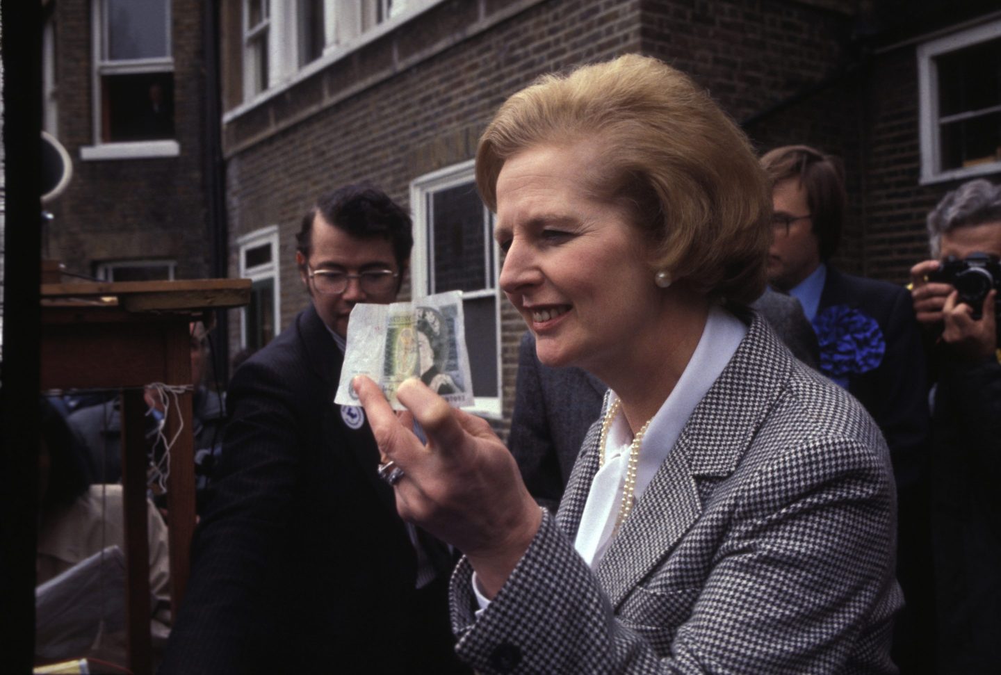 Margaret Thatcher brandishes a banknote following her 1979 election victory.