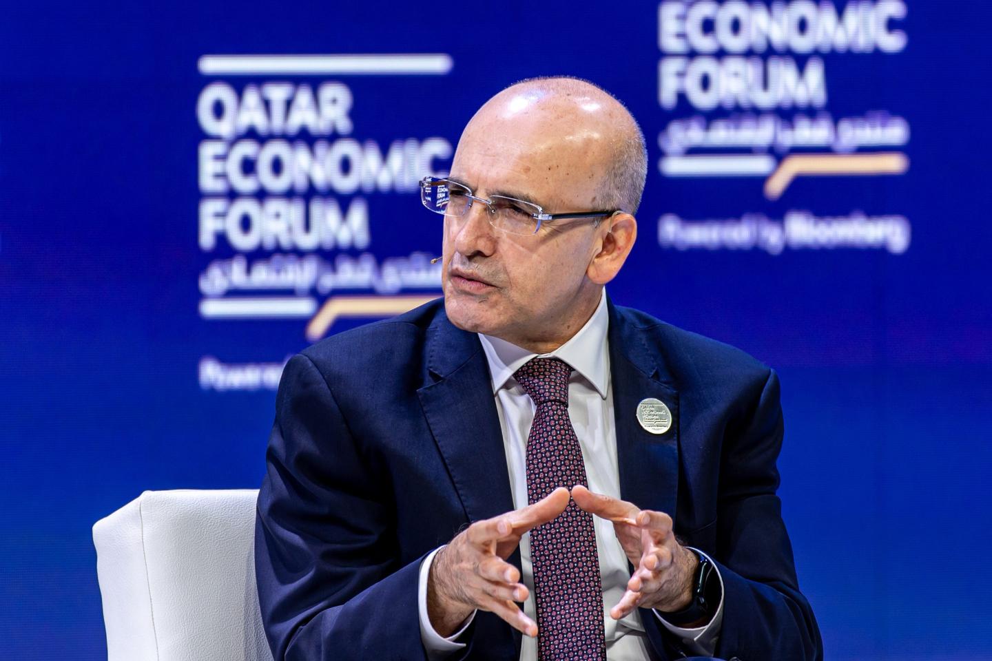 Mehmet Simsek gestures with cradled hands during an interview.