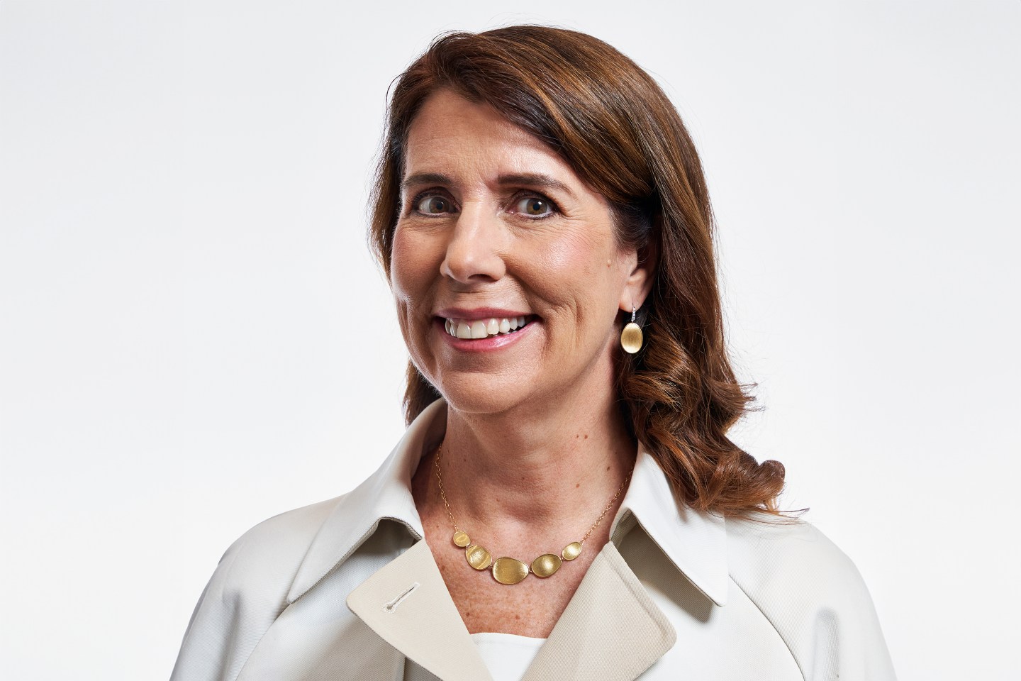 CAVA CFO Tricia Tolivar, wearing a white collared jacket and smiling for a photo