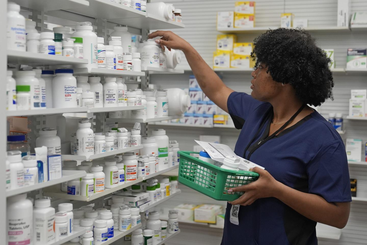 Woman stocks pill bottles on shelves