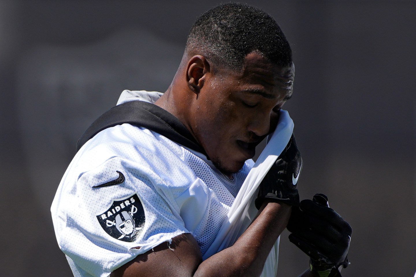 Las Vegas Raiders running back Zamir White wipes sweat from his face during an NFL football practice on June 4, 2024, in Henderson, Nev.