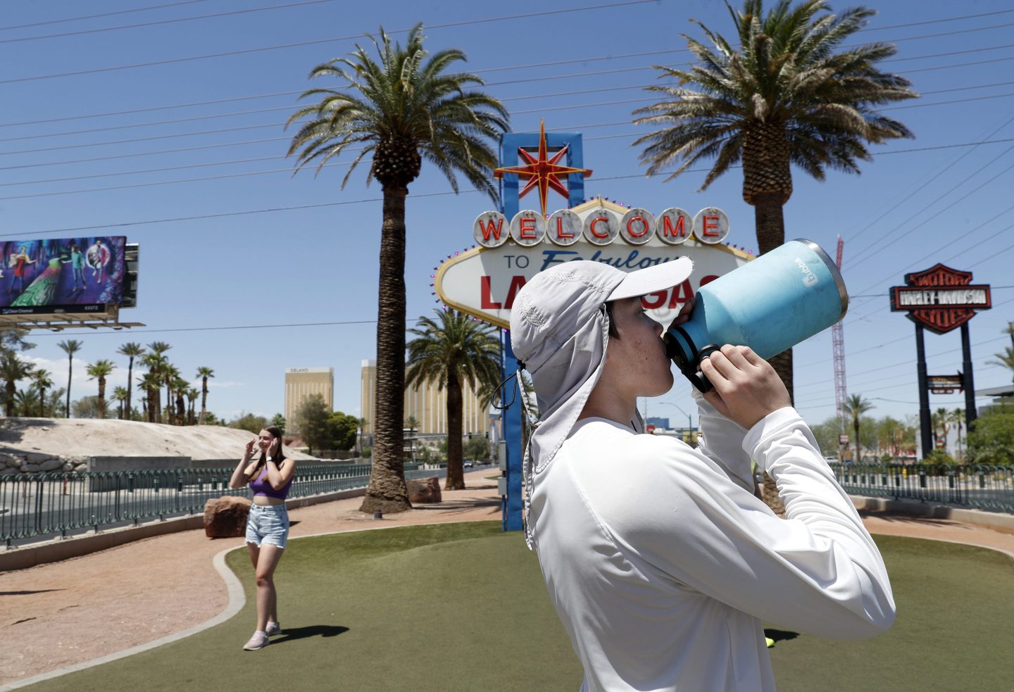 Dean Leano takes a water break while photographing tourists at the Welcome to Fabulous Las Vegas sign in Las Vegas on June 6, 2024.