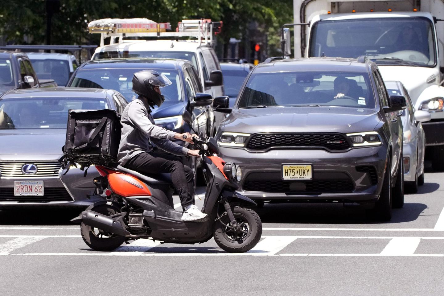 A delivery driver on a scooter