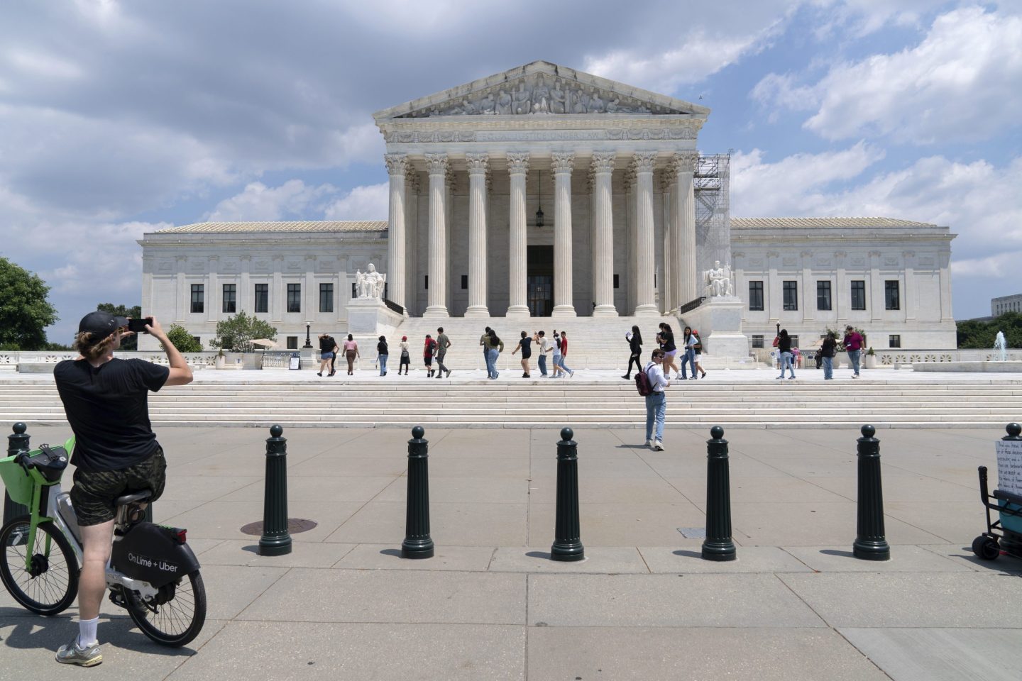 Visitors pose for photographs at the U.S. Supreme Court Tuesday, June 18, 2024, in Washington.