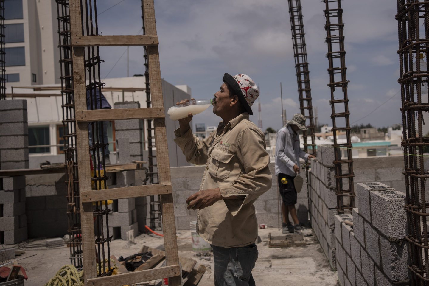Jorge Moreno, a worker, drinks flavored water to cope with the heat wave during his workday at a construction site in Veracruz, Mexico, on June 17, 2024.