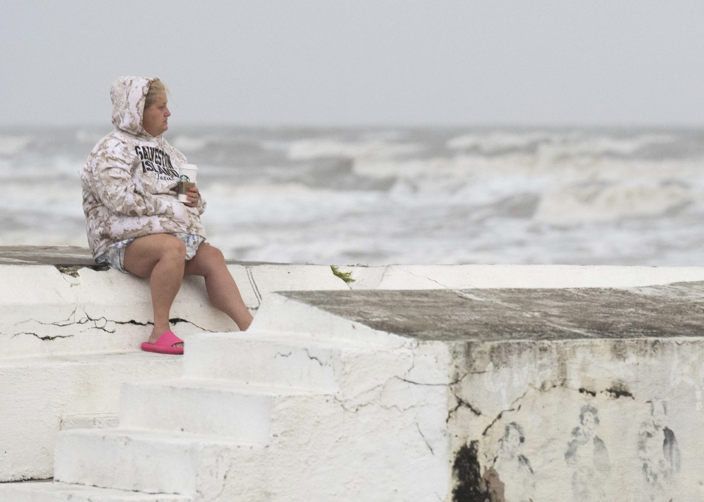Woman sits on sea wall