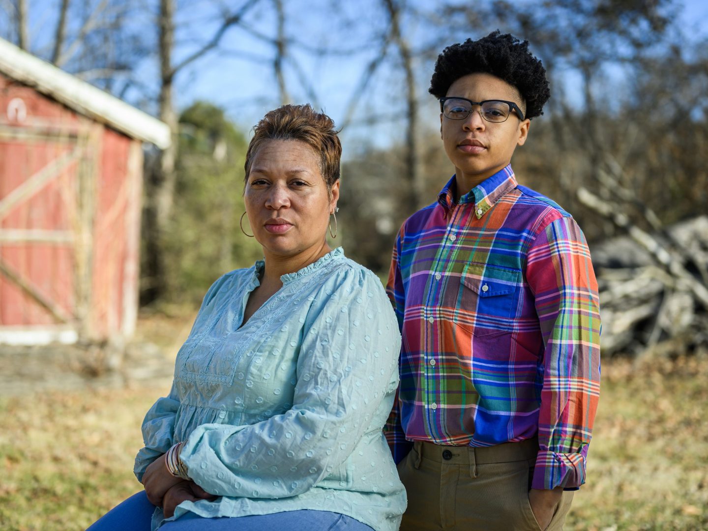 A woman and her daughter powe for a portrait outdoors