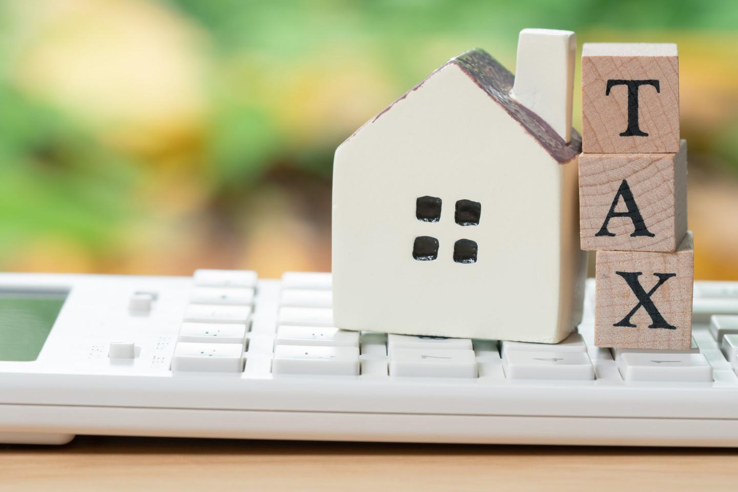 model house and wood blocks that spell tax