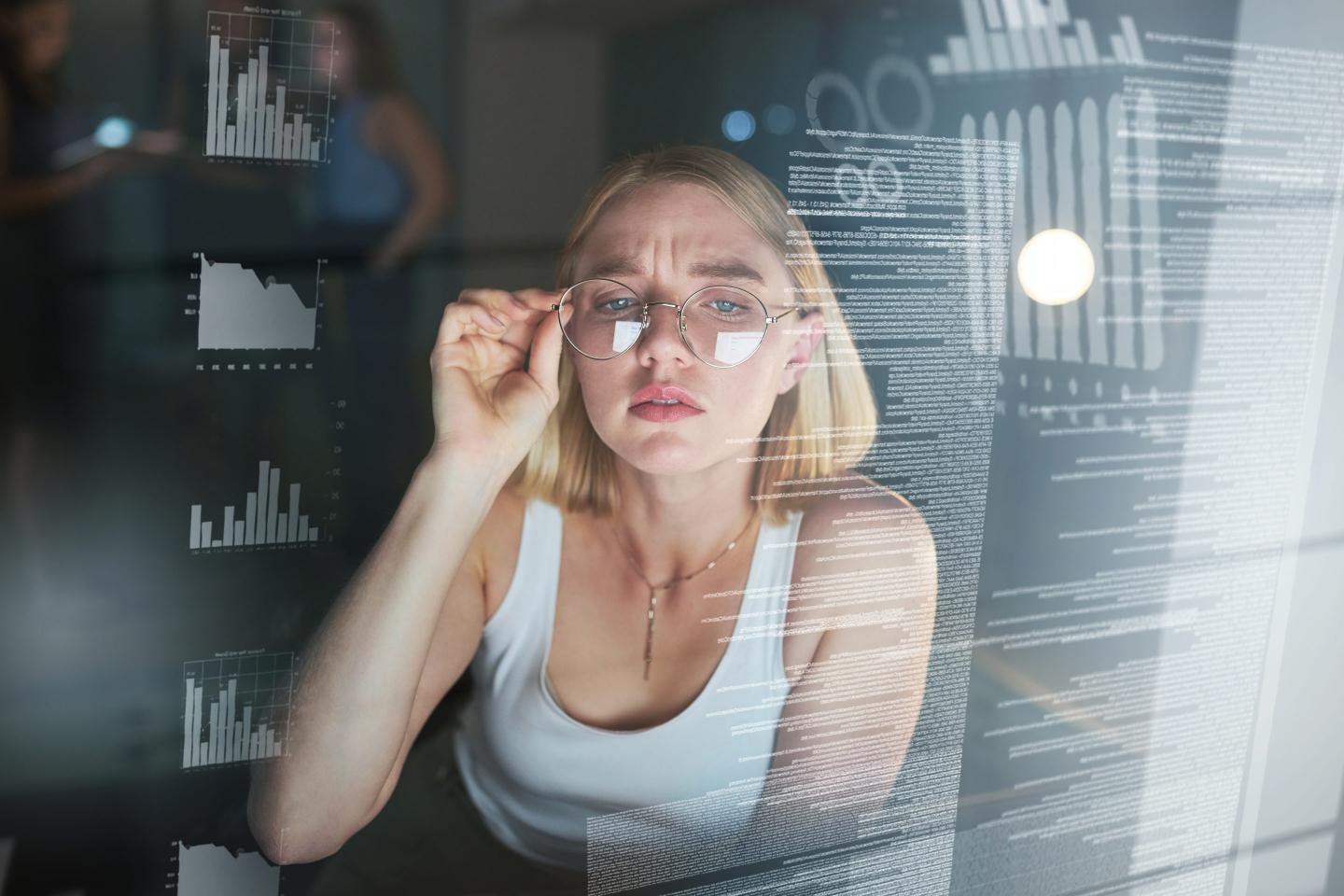 A worker looks confused at the data before her.
